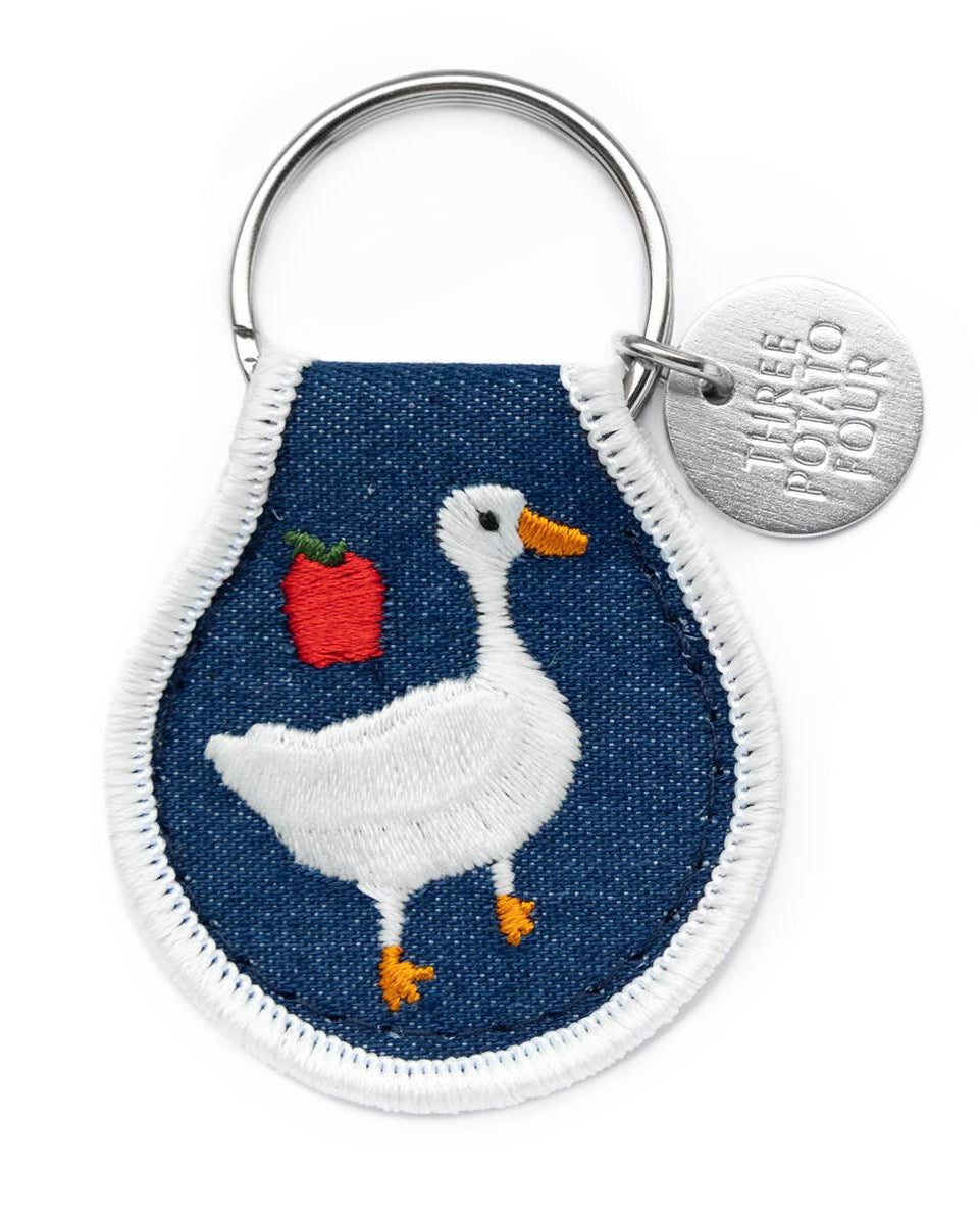 Keychain with a goose design on a blue background.