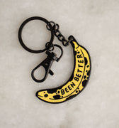 Enamel and metal keychain in the shape of a bruised banana featuring the phrase "been better"