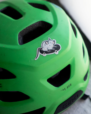 Reflective sticker of a cute rat on a skateboard shown on a child's bike helmet