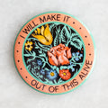 Round magnet with central floral design encircled by the words "I will make it out of this alive"