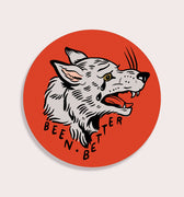 circular sticker of grey wolf with mouth open and black tears on red background with text reading "Been Better" 