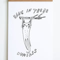 white background with loose line drawing in black of cat hanging from tree branch with text hang in there dumbass above and below image 